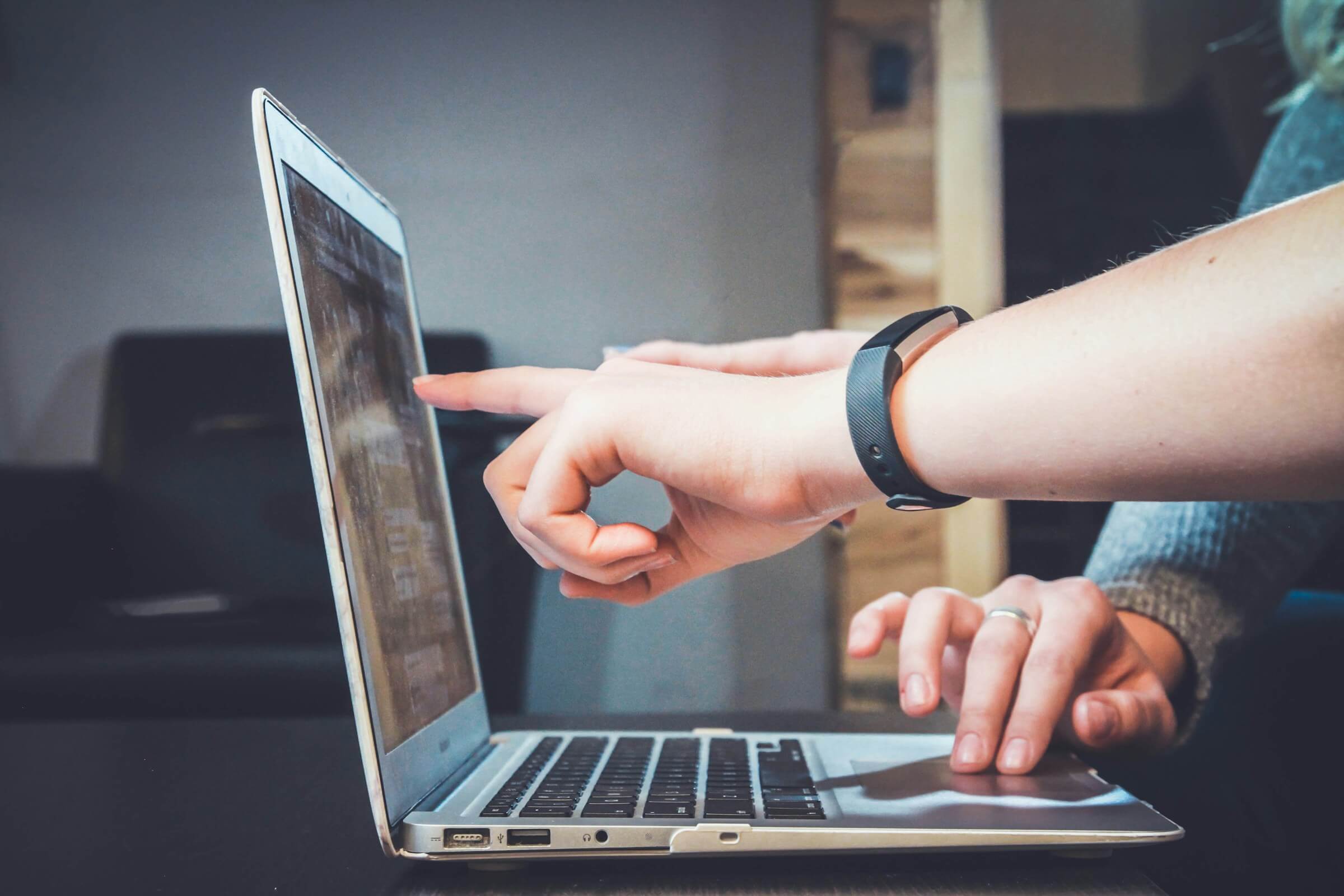 2 people collaborating infront of a laptop